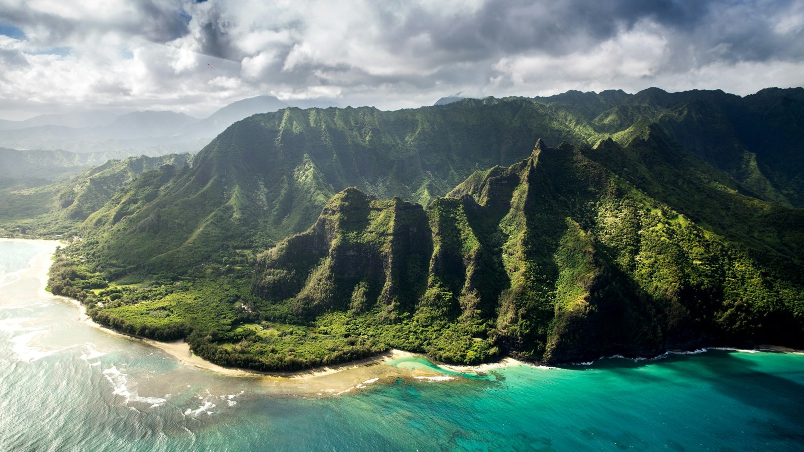 Aerial view of Kauai's mountains meeting the coastline.