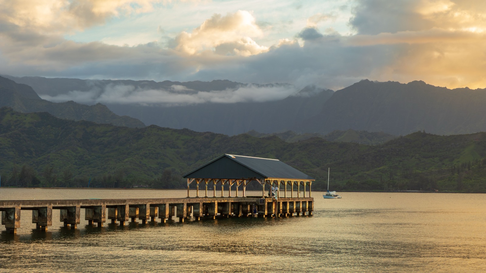 Hanalei Pier beneath the mountains at sunset.