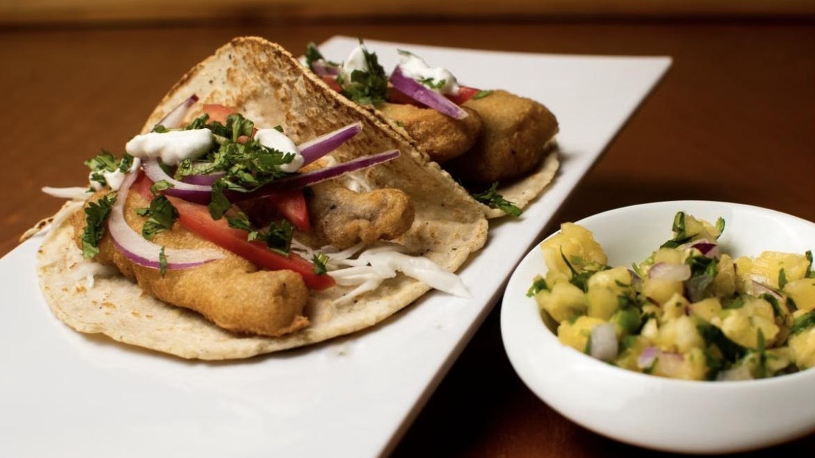 Illustrative stock photo of crispy fish tacos with pineapple salsa.