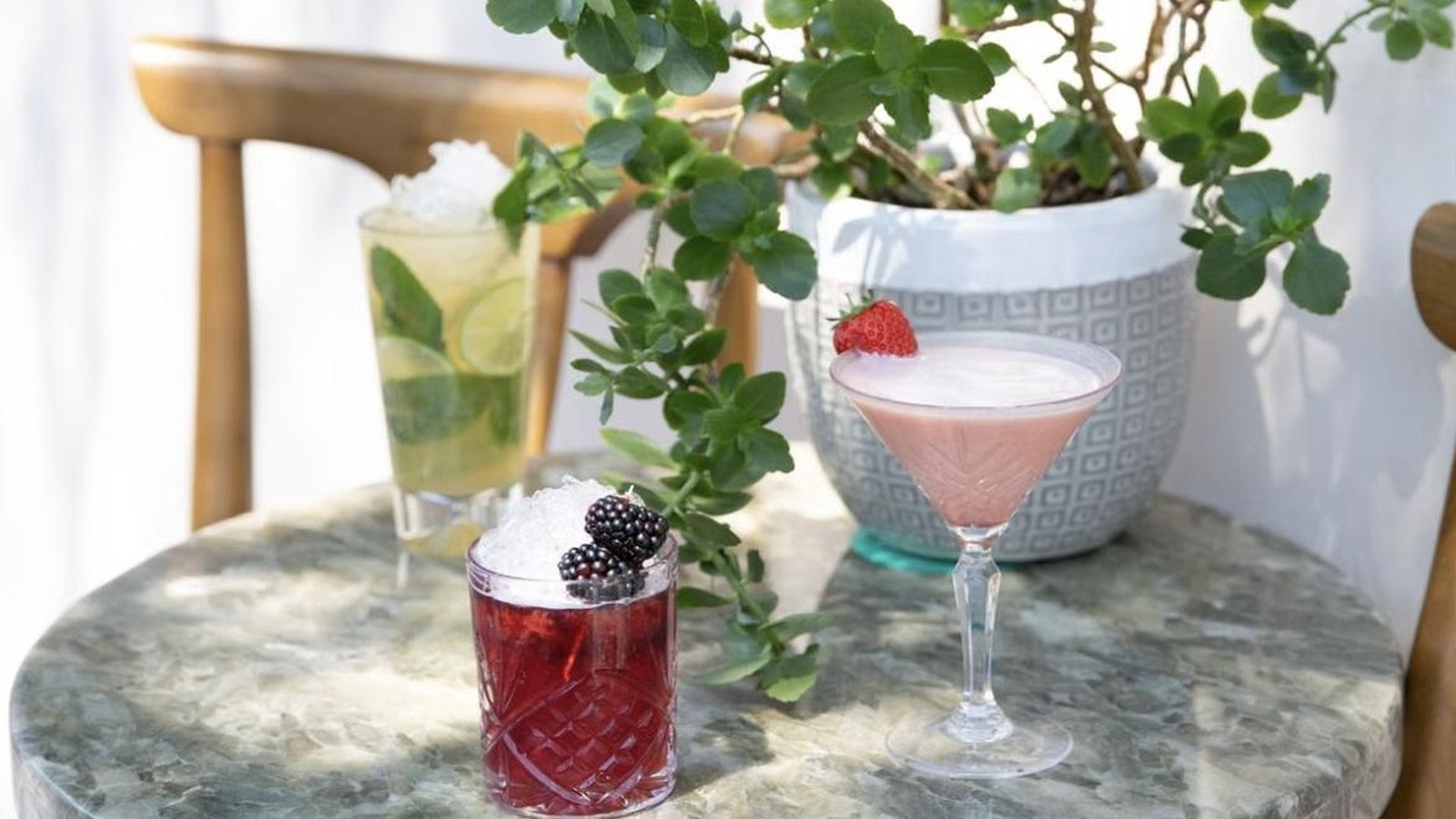Illustrative stock photo of cocktails on a marble table.
