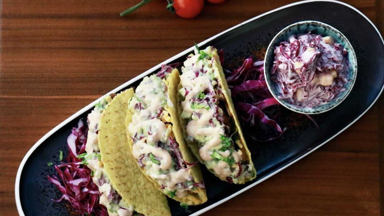 Illustrative stock photo of fish tacos with creamy sauce and red cabbage salad.