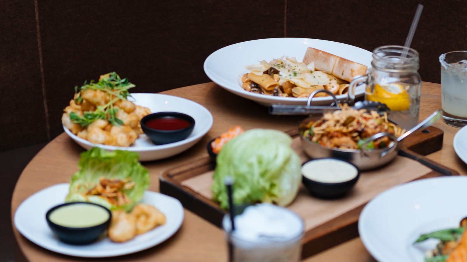 Illustrative stock photo of shared restaurant plates and drinks.
